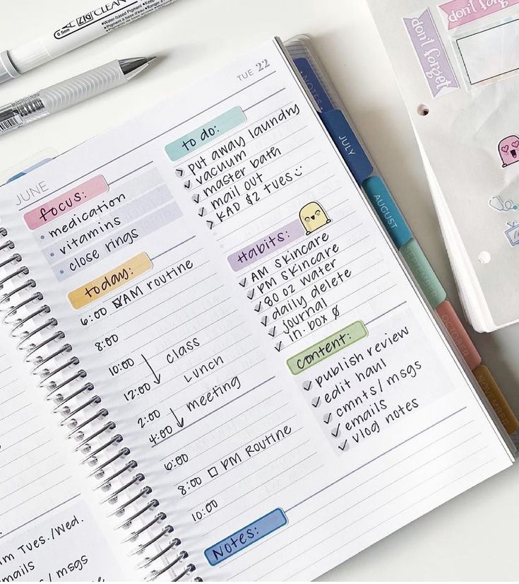 an open notebook with stickers on it next to a pen