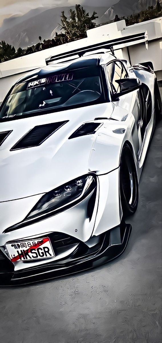 a white sports car parked in front of a building