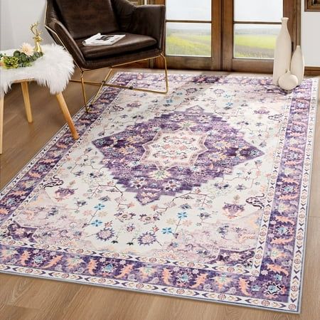 a living room area with a large rug on the floor and a chair next to it