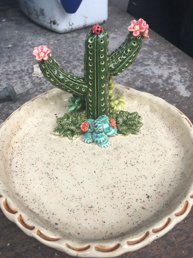 a ceramic cactus sitting on top of a white plate