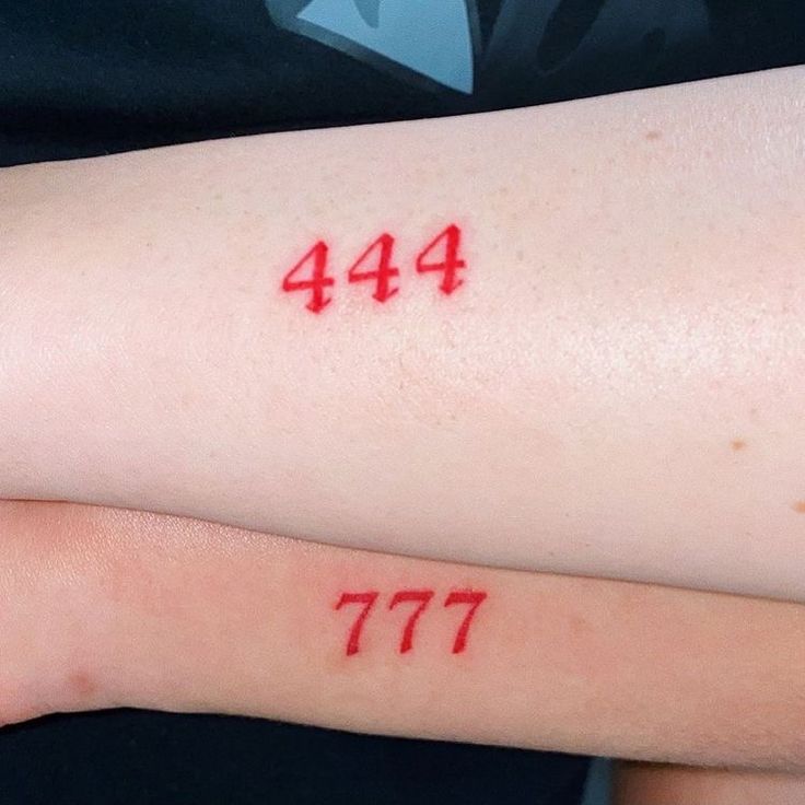 two people with red numbers on their arm and one has the number 477 written on it