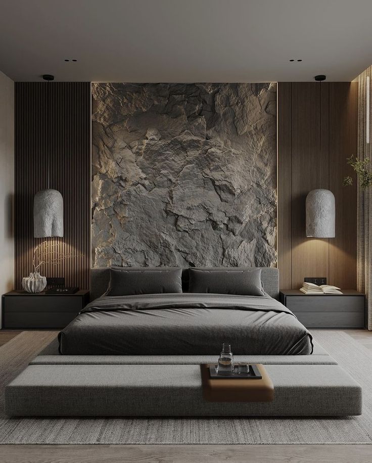 a large bed sitting in a bedroom next to a wall covered in rocks and plants