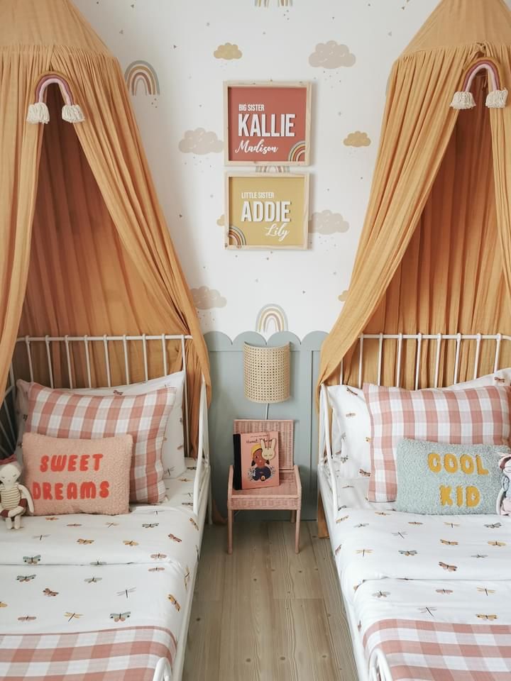 two twin beds in a bedroom with orange drapes on the walls and plaid bedding