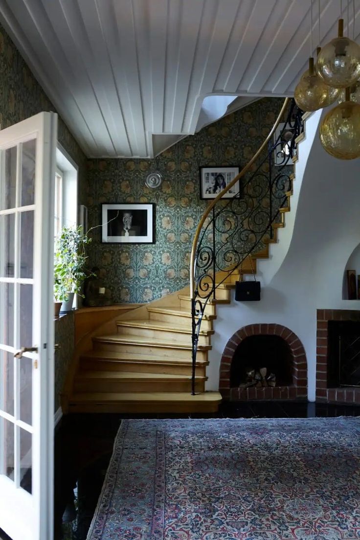 a living room with stairs and pictures on the wall