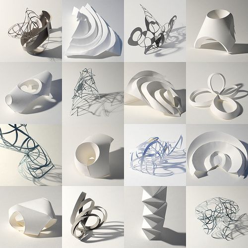 many different shapes and sizes of paper on a white surface with shadows coming from them