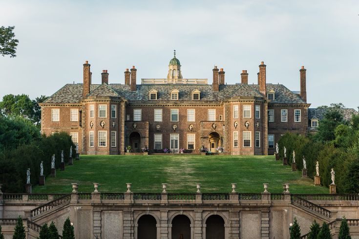 a large brick building sitting on top of a lush green field