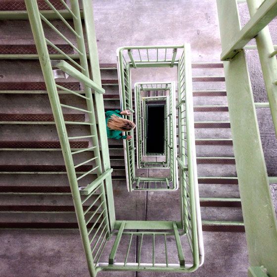 an overhead view of a green shopping cart with someone's hand on the handle