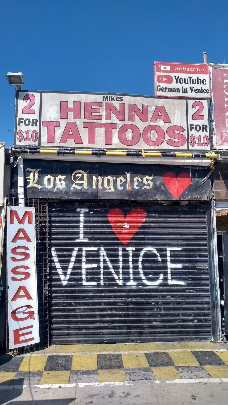 an old garage with lots of signs on the front and back doors that say i love venice