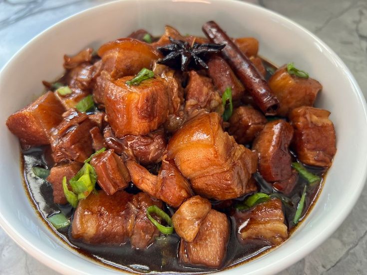 a white bowl filled with meat and vegetables