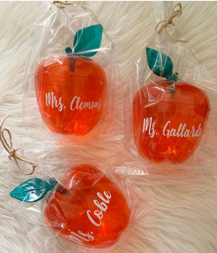 three plastic apples with their names on them