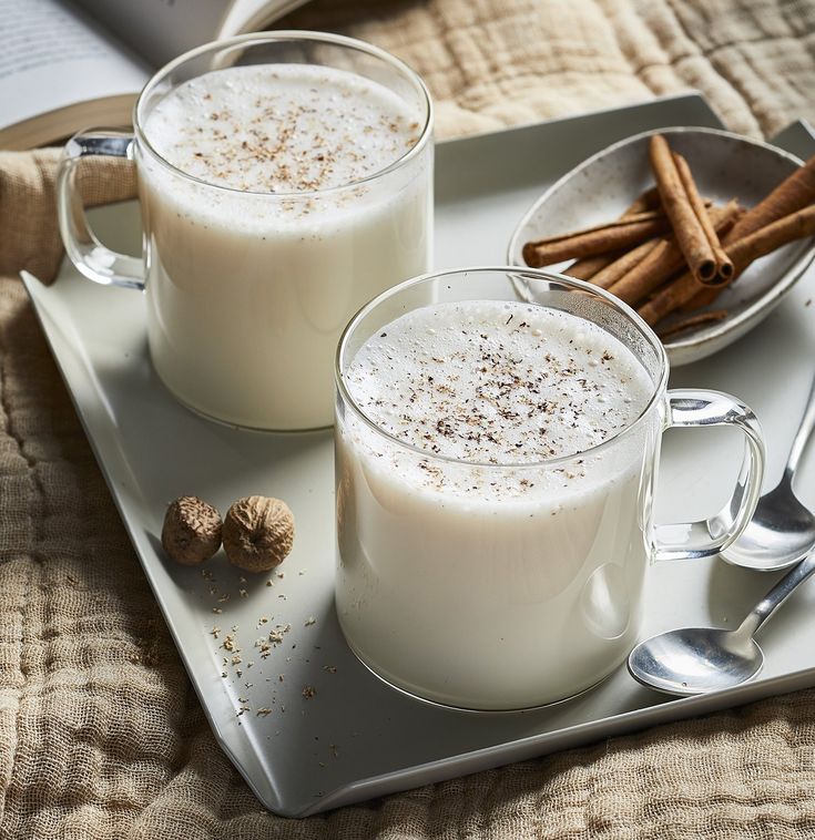 two glasses of milk and cinnamon on a tray