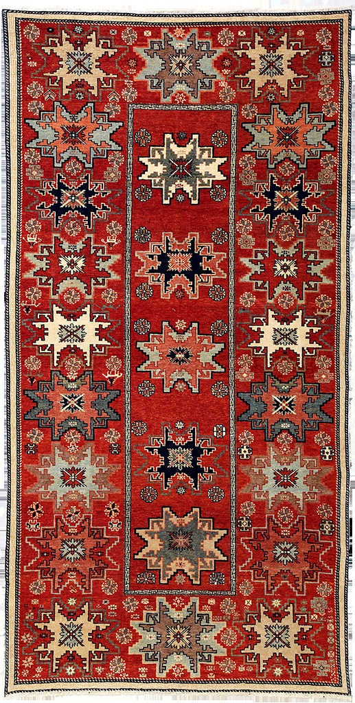 an old rug with many different colors and designs on the carpet, including red tones