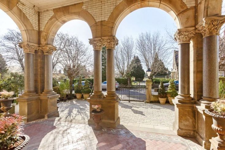 an outdoor area with arches and potted plants