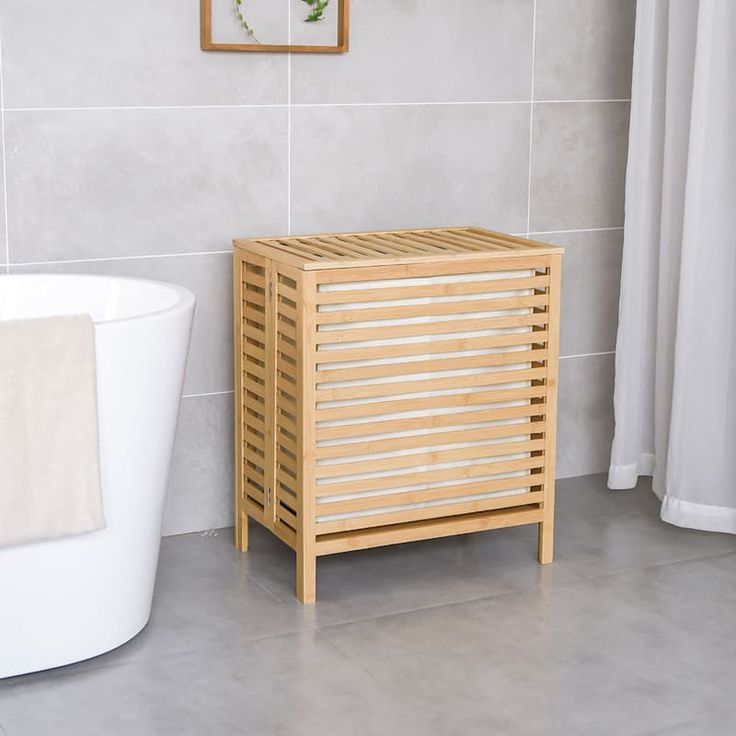 a white bath tub sitting next to a wooden cabinet