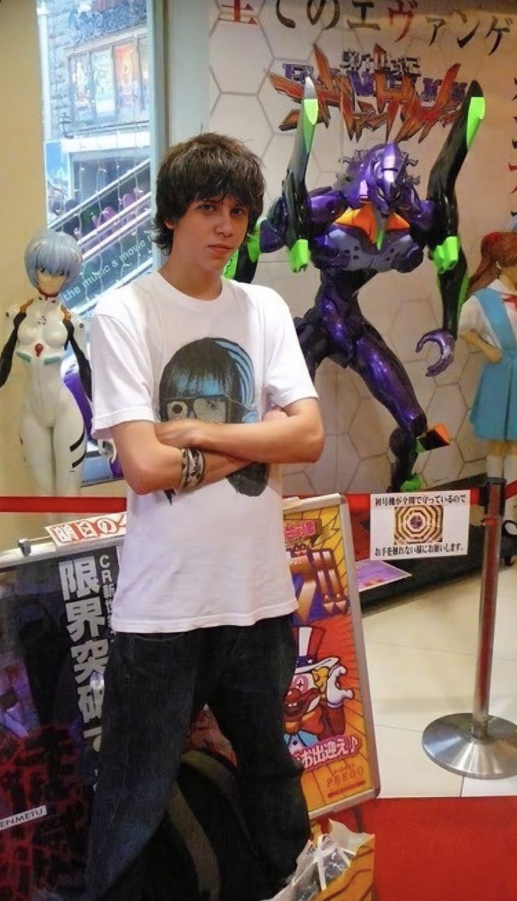 a young man is standing in front of some action figures