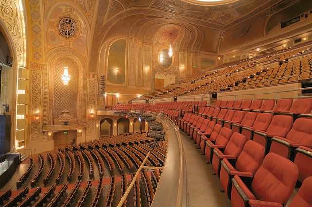 an empty auditorium with rows of red seats