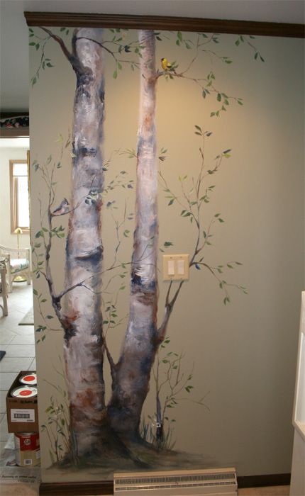 there is a mural on the wall in this kitchen that depicts two trees and birds