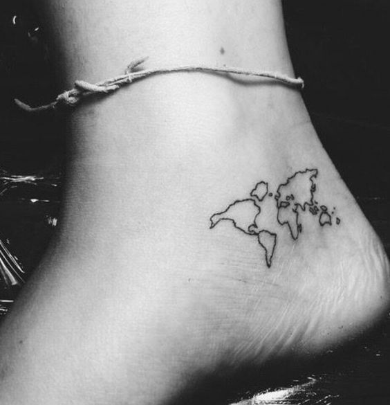 a black and white photo of a world map tattoo on the side of a foot