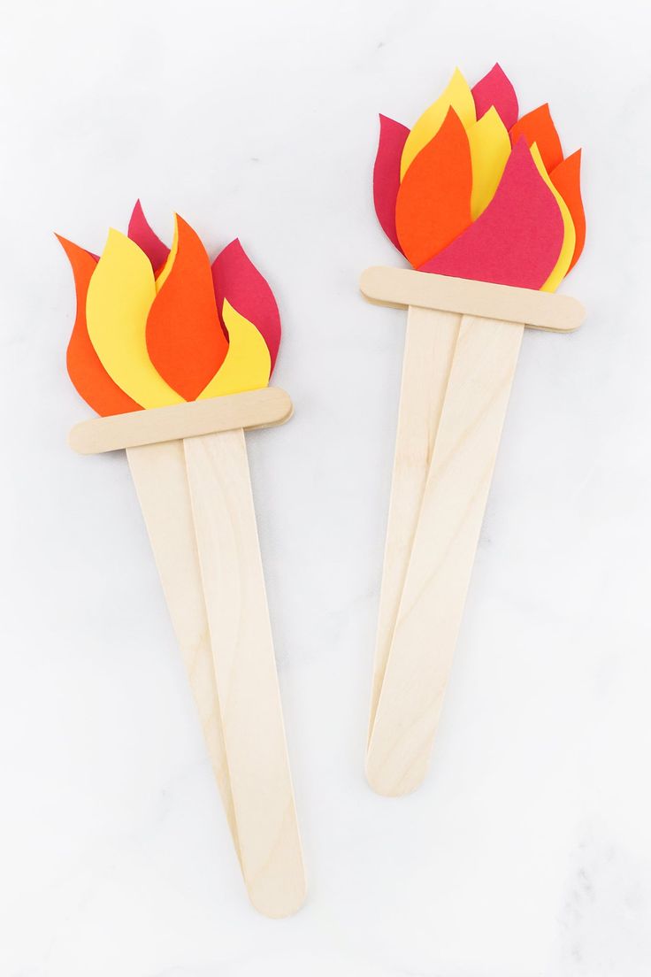 two popsicle sticks with flames on them sitting next to each other in front of a white background