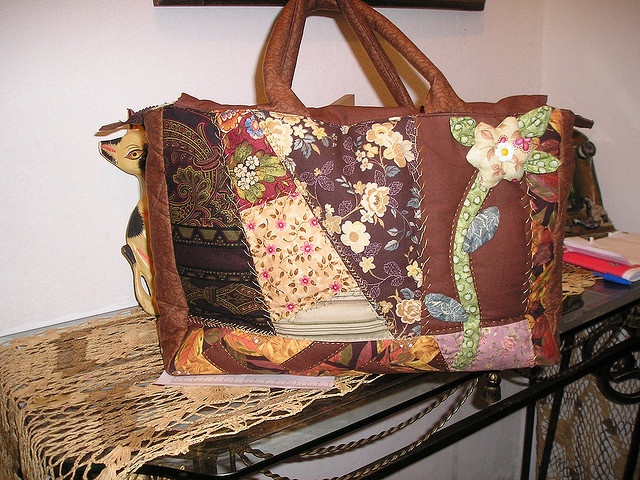 a purse sitting on top of a table next to a book shelf with books in it