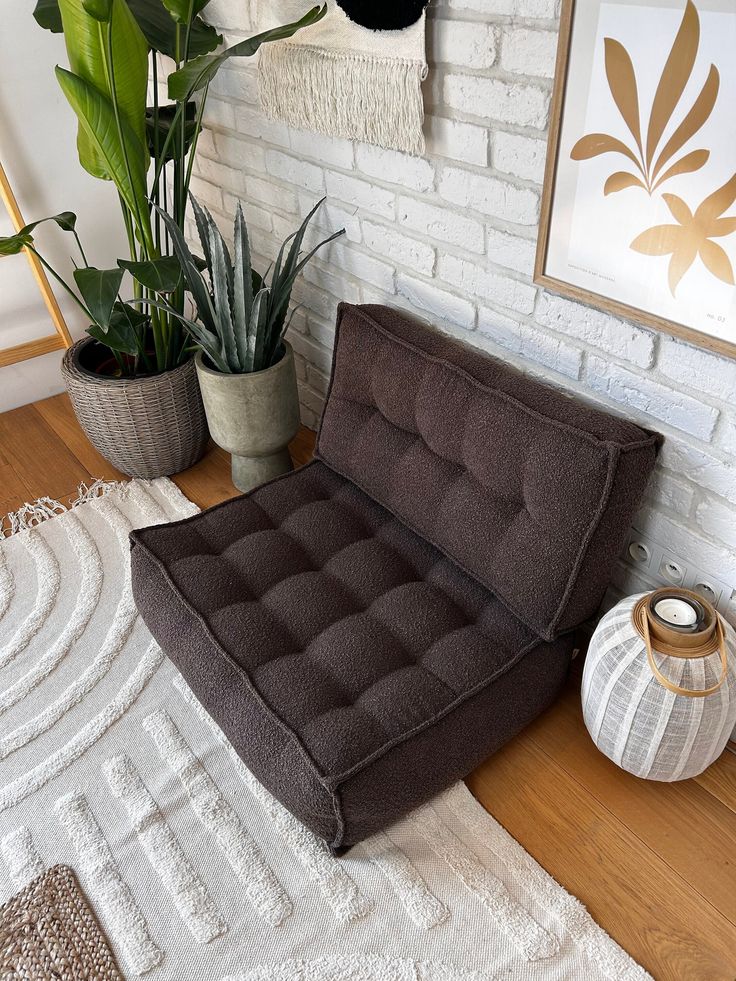 a brown chair sitting on top of a wooden floor next to a potted plant