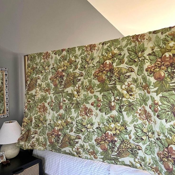 a bed with a floral wallpaper covering it's headboard and night stand