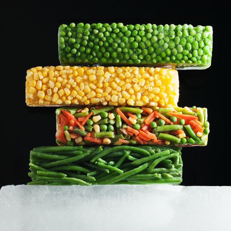 corn, carrots, and green beans are stacked on top of each other in the shape of a stack