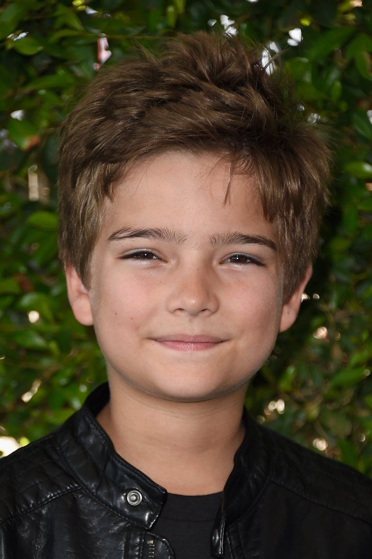 a close up of a young person wearing a leather jacket and smiling at the camera