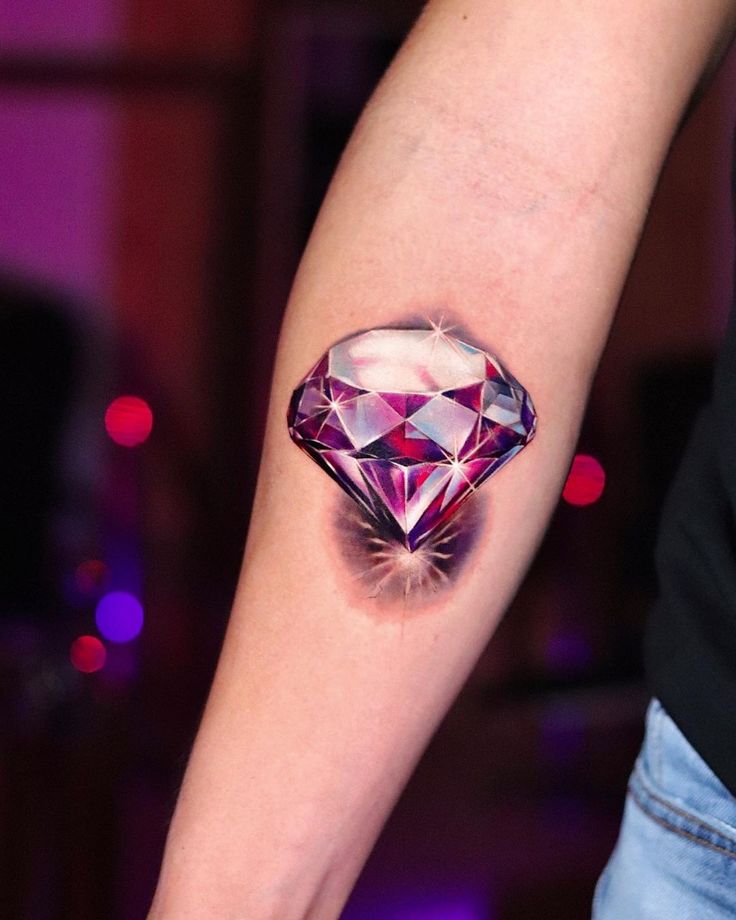 a woman's arm with a diamond tattoo on it