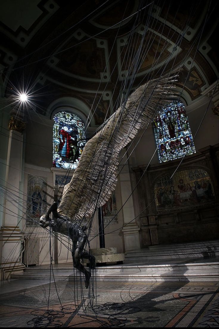 an artistic sculpture is shown in the middle of a room with stained glass windows and chandeliers