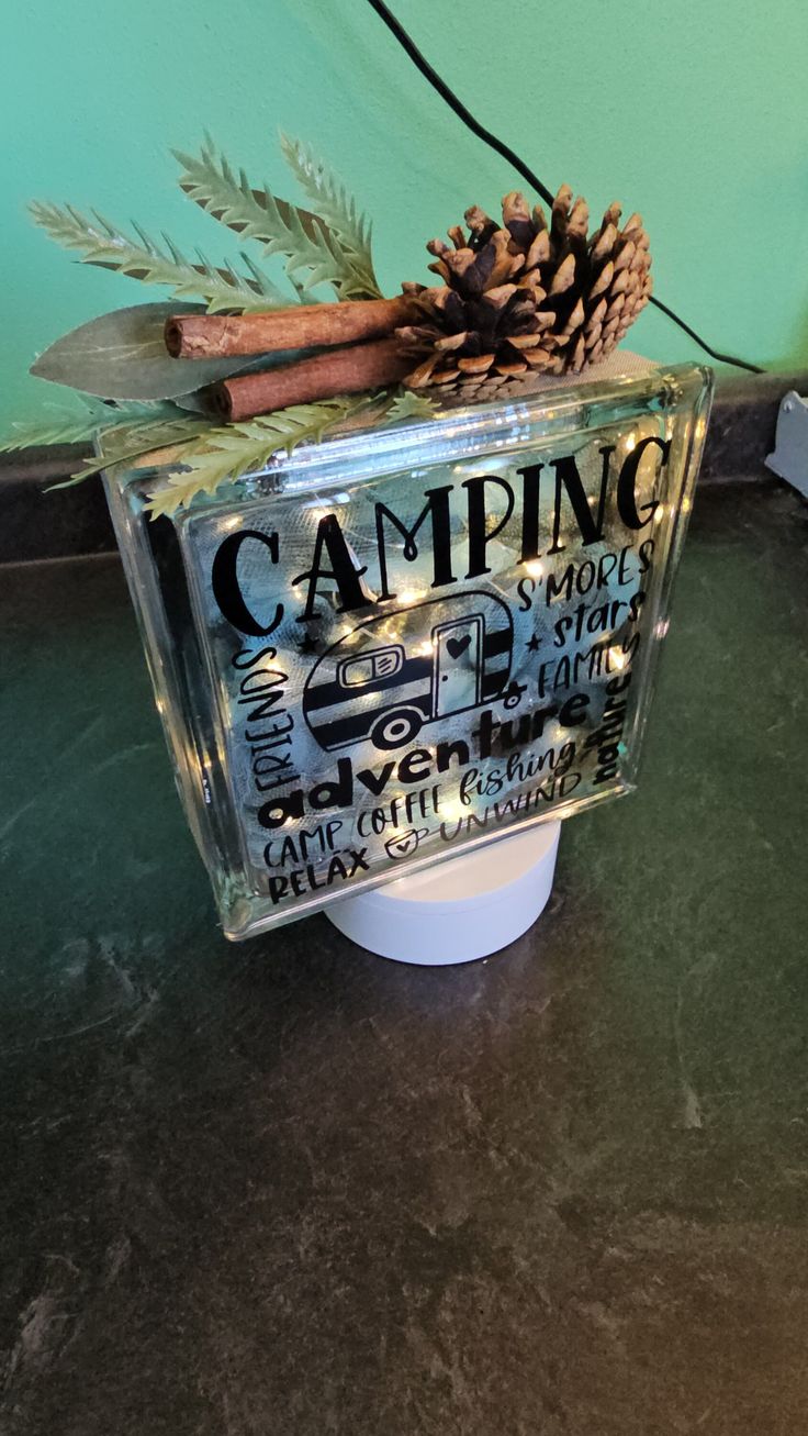 a camper mug with a pine cone on top and writing on the side that says camping