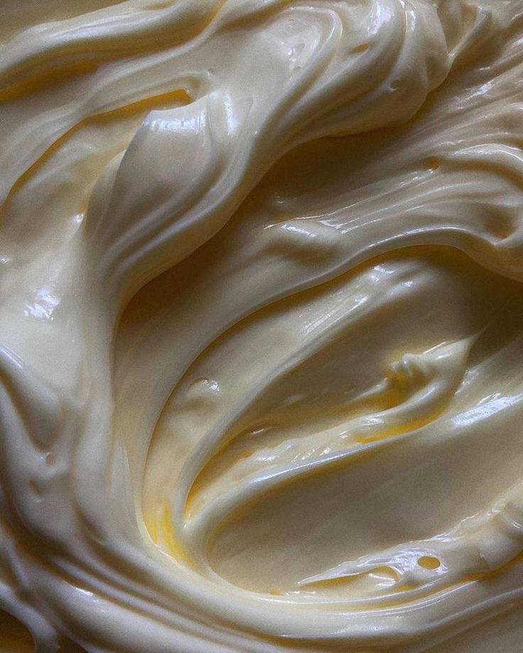 a close up view of whipped cream on a plate with yellow and white swirls