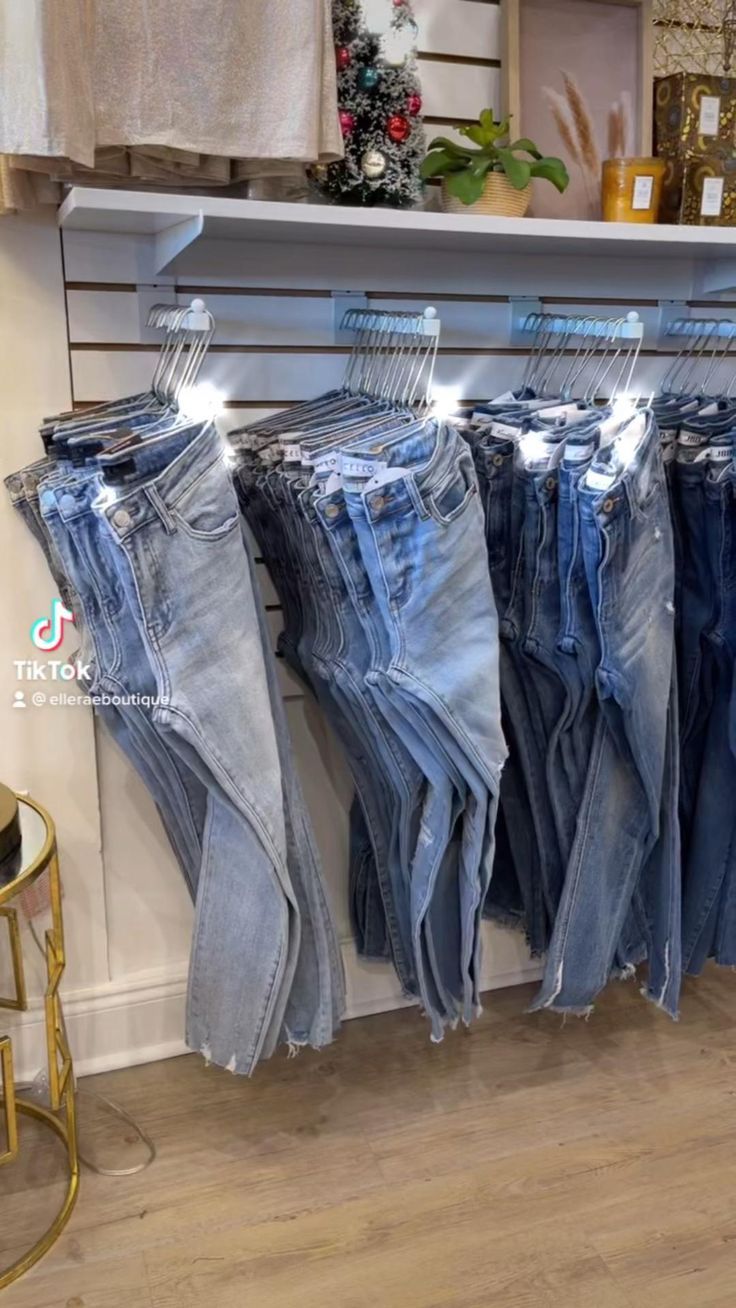 several pairs of jeans are hanging on a rack