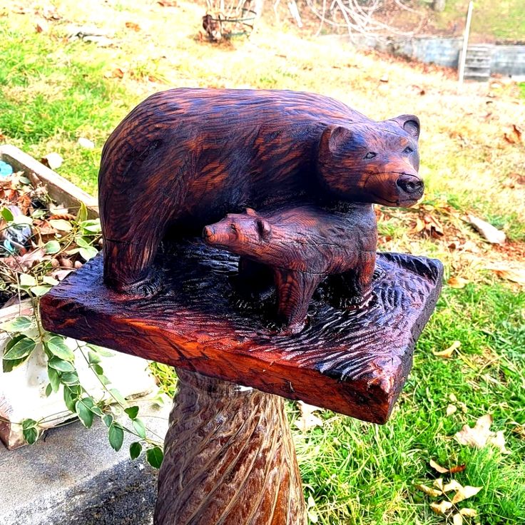 a bear statue sitting on top of a tree stump