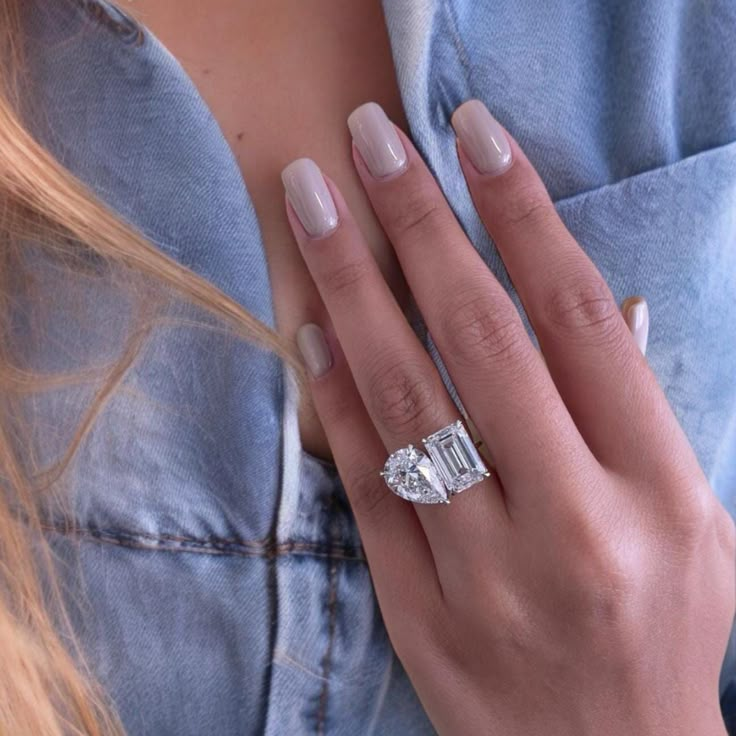 a woman's hand with an engagement ring on her left and a diamond in the middle