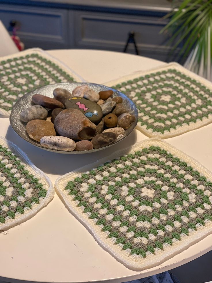 a bowl filled with rocks sitting on top of a table next to two place mats