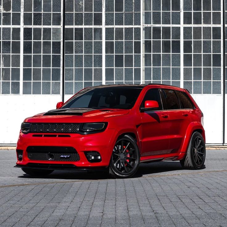 a red jeep parked in front of a building