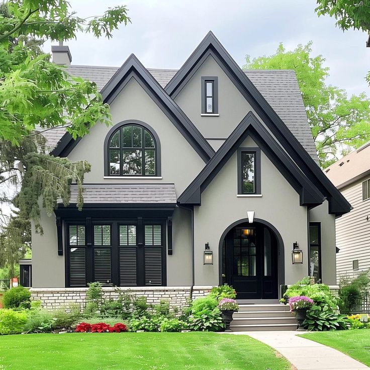 a gray house with black shutters on the front door and windows in the side