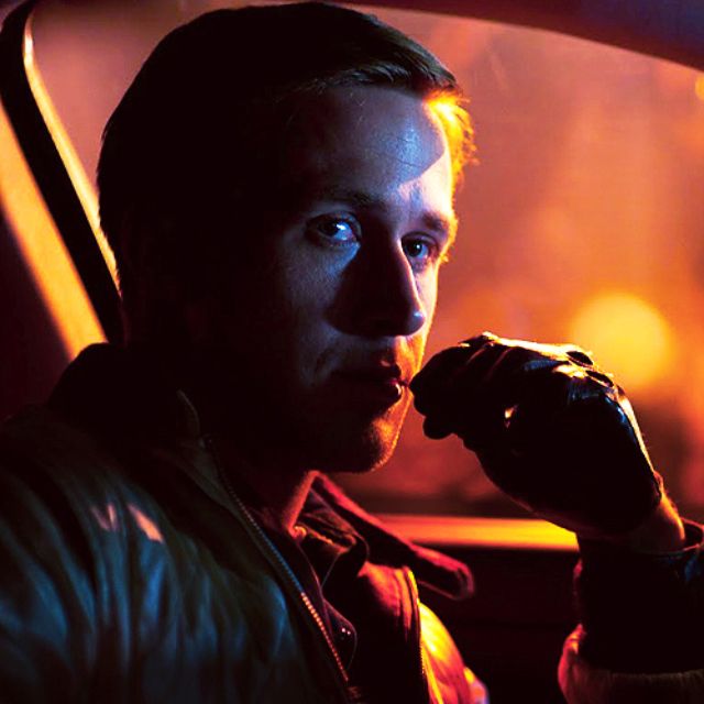 a man sitting in the back seat of a car eating something out of his hand