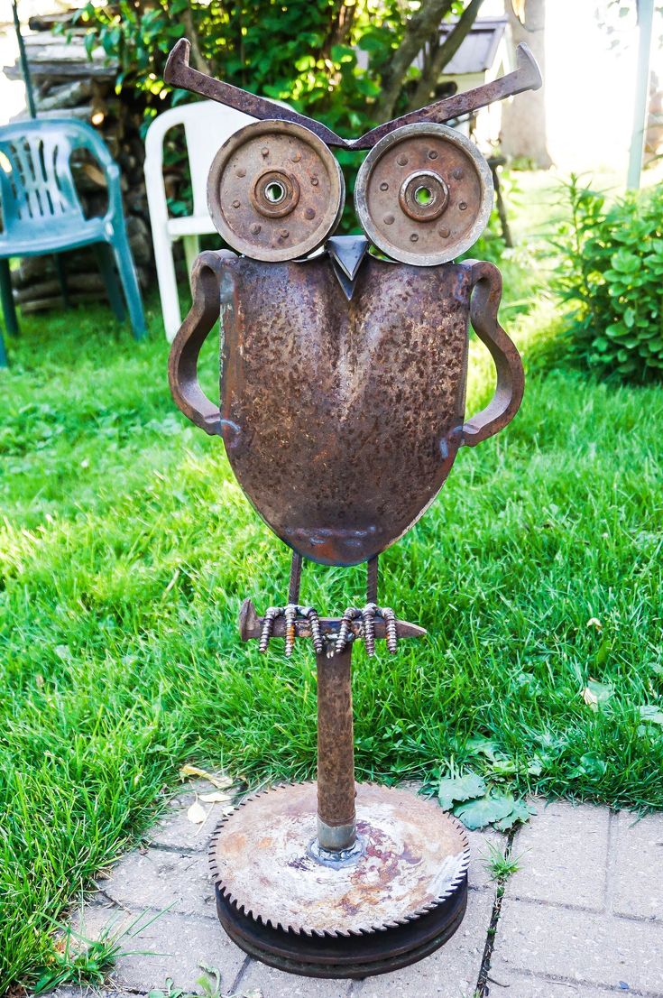 an owl statue sitting on top of a metal stand