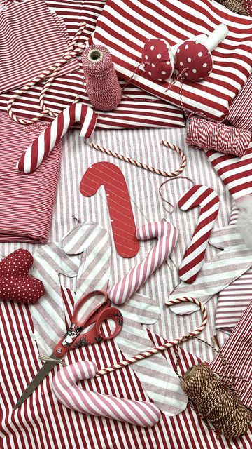 red and white striped fabric with scissors, thread, pins and other items on it