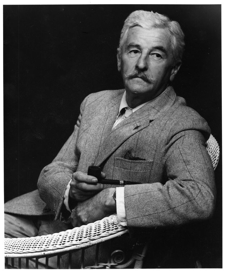 an old black and white photo of a man in a suit with a pipe sitting on a chair