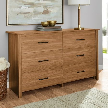 a large wooden dresser sitting in a living room next to a painting on the wall