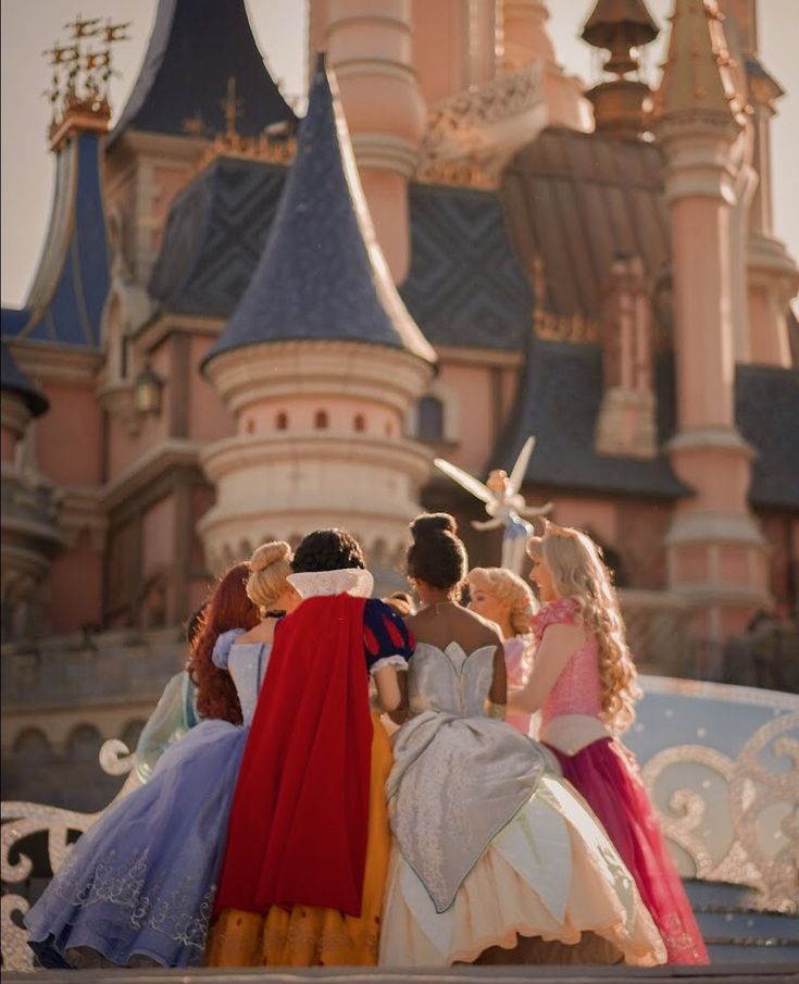 some princesses are standing in front of a castle