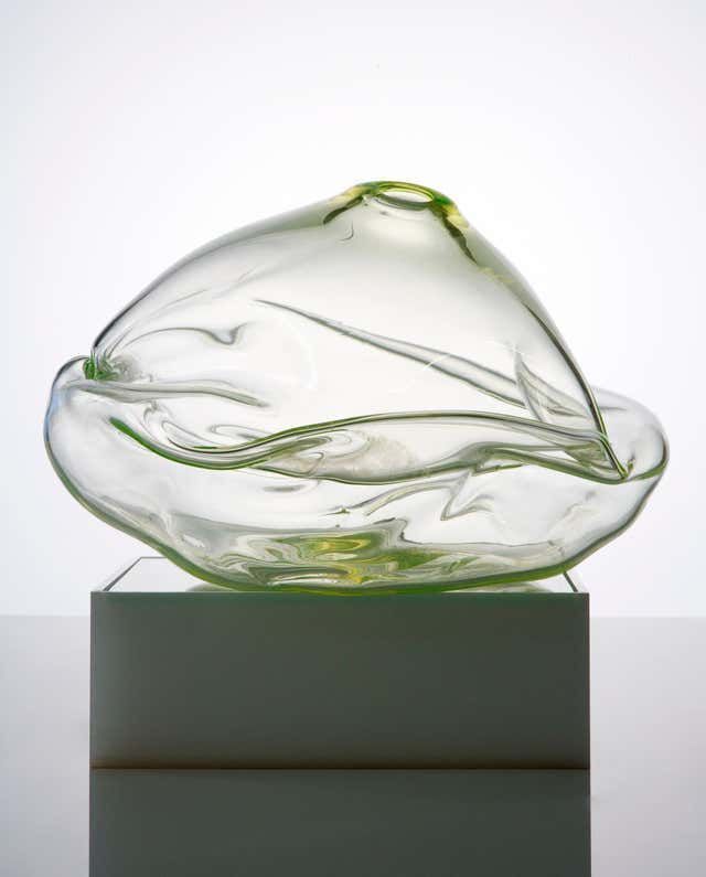 a clear glass vase sitting on top of a white table next to a black box