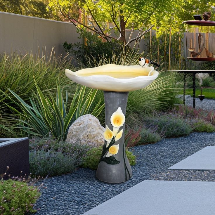 a bird bath sitting in the middle of a garden