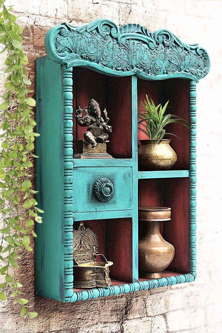 a blue shelf with pots and vases on it next to a wall mounted planter