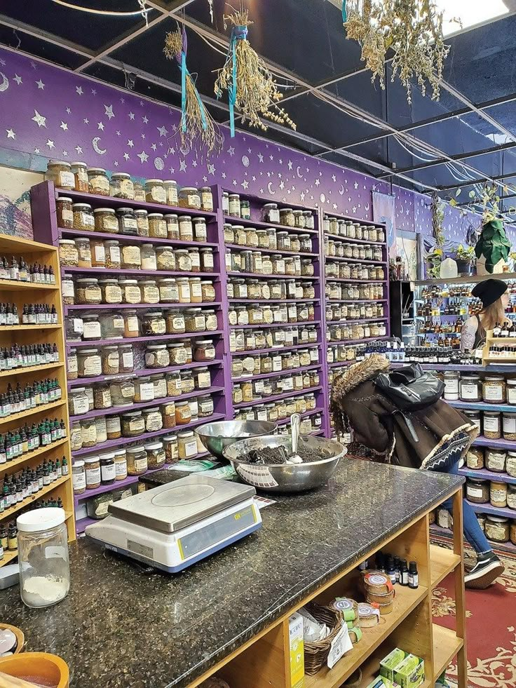 a store filled with lots of jars and containers on shelves next to a counter top