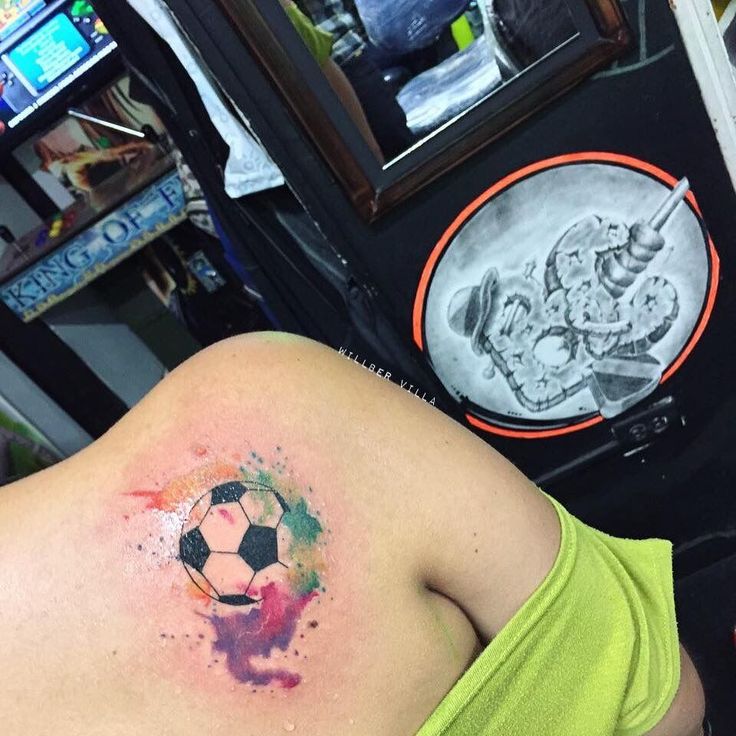 a woman with a soccer ball tattoo on her back