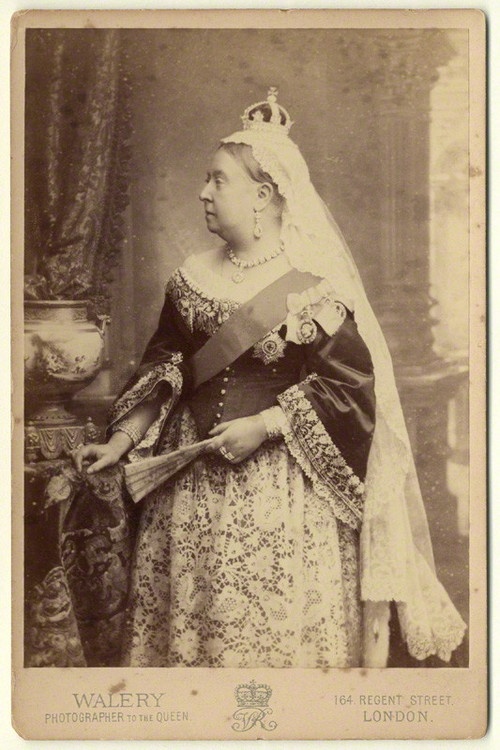 an old photo of a woman wearing a tiara and holding a book in her hand